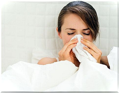 Woman with cold blows her nose