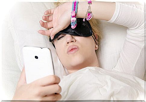 woman in bed looking at mobile